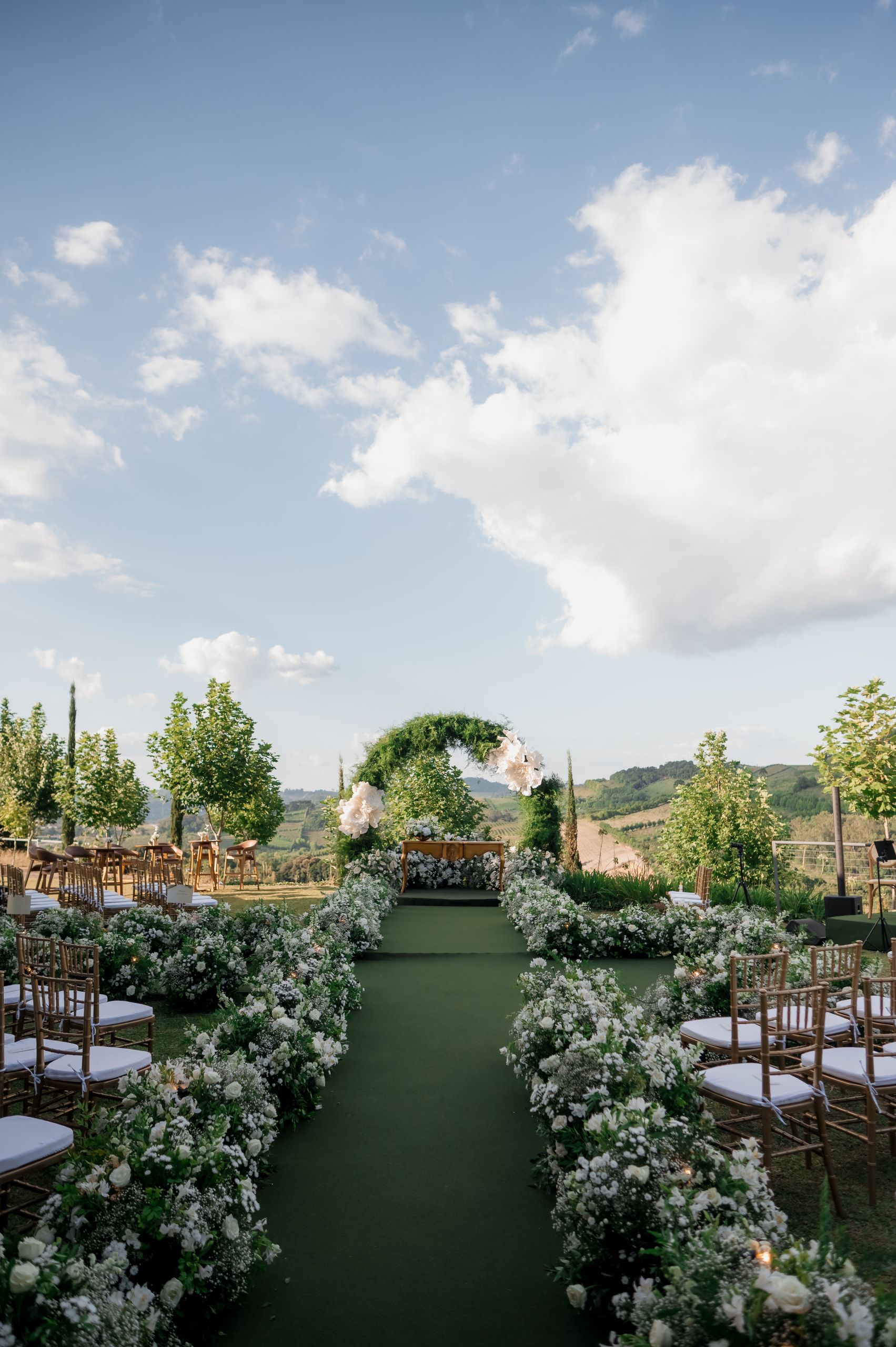 Stunning outdoor wedding ceremony with floral arch and scenic views.